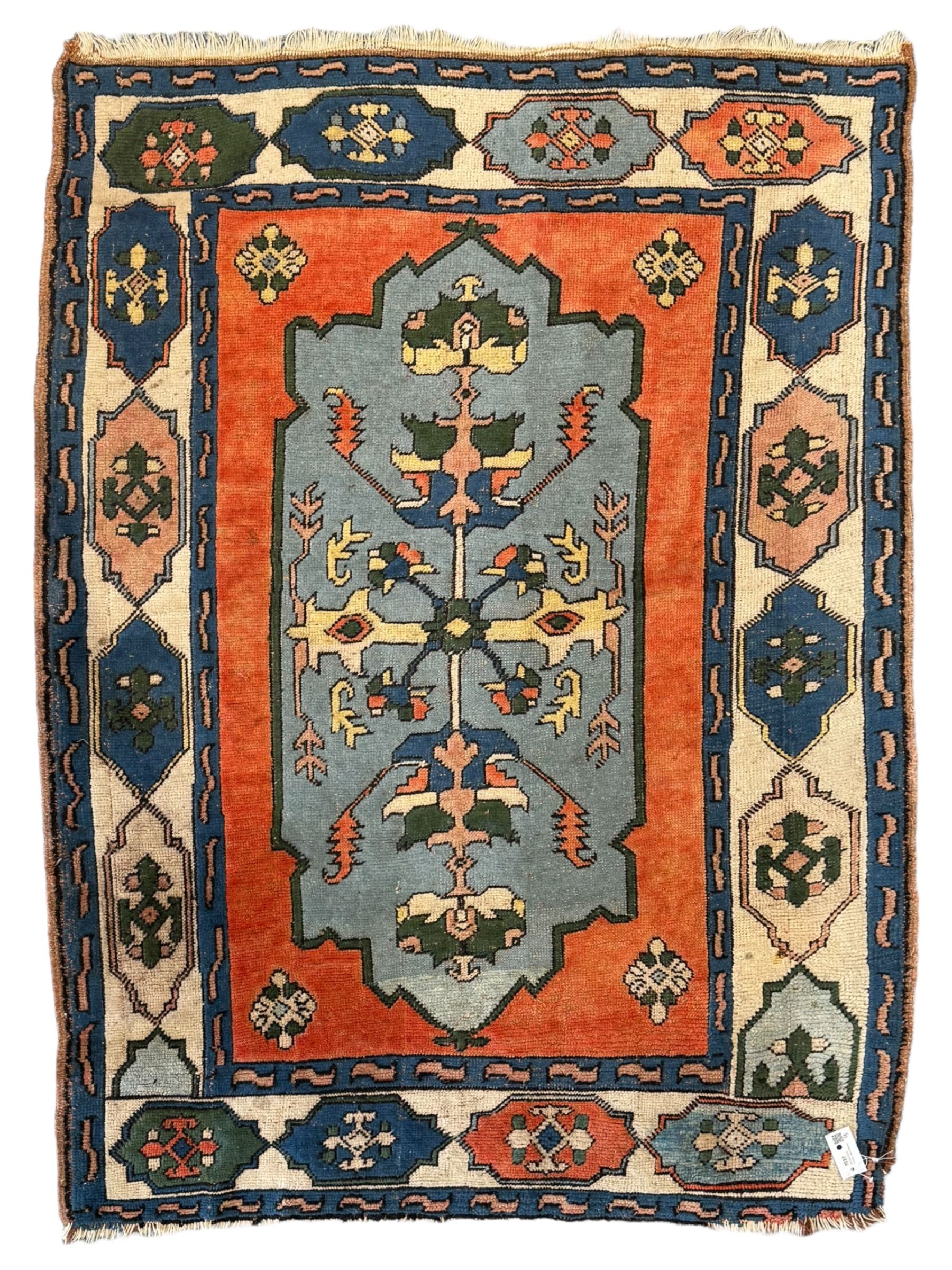 Turkish indigo ground rug, the shaped central field decorated with a central geometric stylised plant motif, enclosed with a guarded border decorated with contrasting motifs 