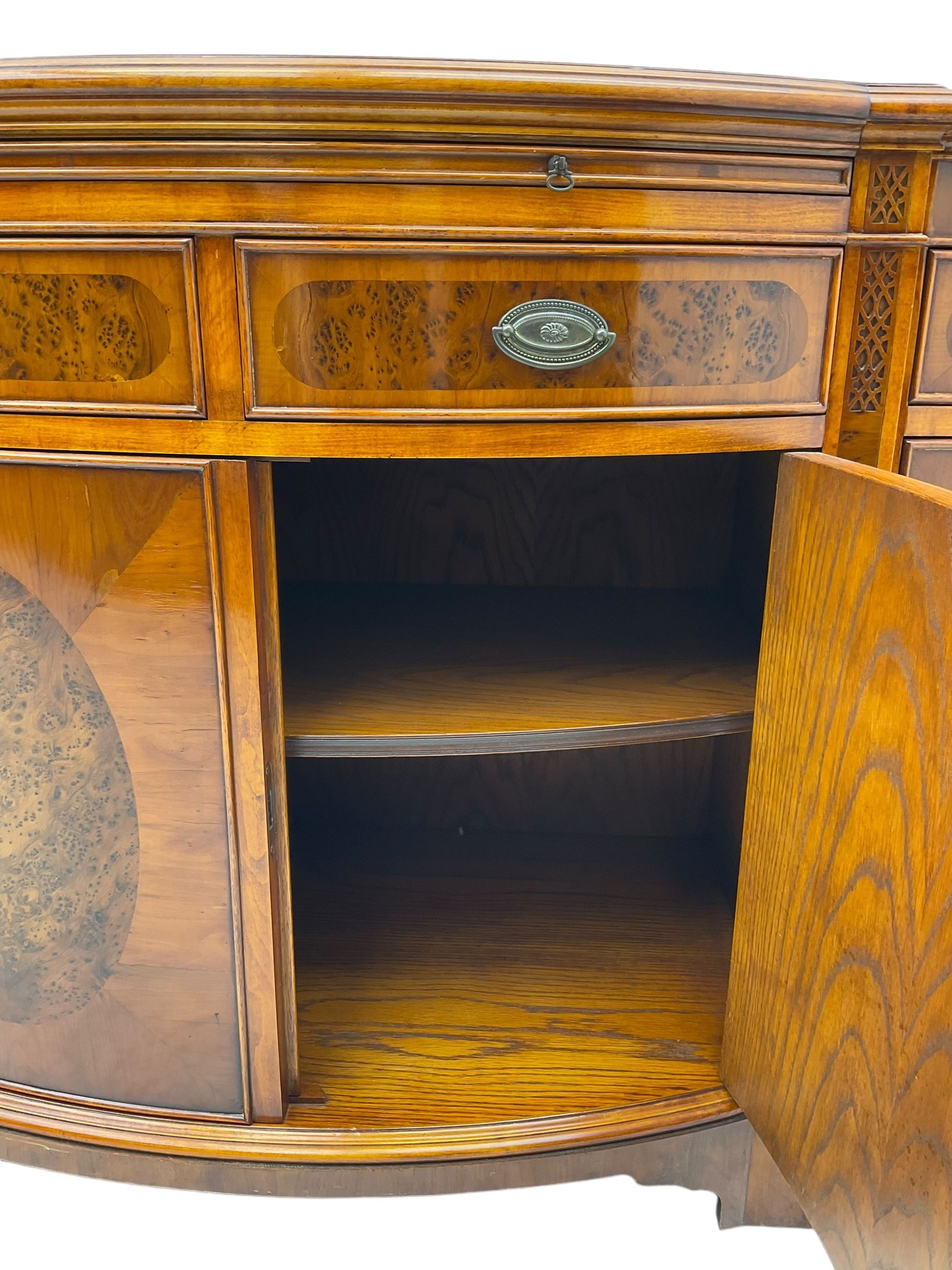 Wade - Georgian design yew wood bow-fronted sideboard, projecting moulded top over four cockbeaded frieze drawers, the central two with pull-out slides, four cupboards below with figured veneers, raised on bracket feet