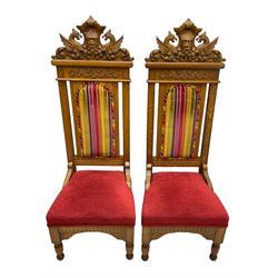 Set of six 20th century Carolean design oak high back chairs, the pediment carved with dragons and central Green Man mask with trailing foliage, the backs upholstered in striped fabric, on turned front supports