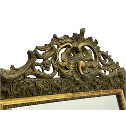 Victorian giltwood and gesso wall mirror, pierced shell cartouche pediment decorated with C-scrolls and curled leaves, moulded frame with curled acanthus leaf decoration and beaded inner slip, the corner brackets decorated with flower heads 