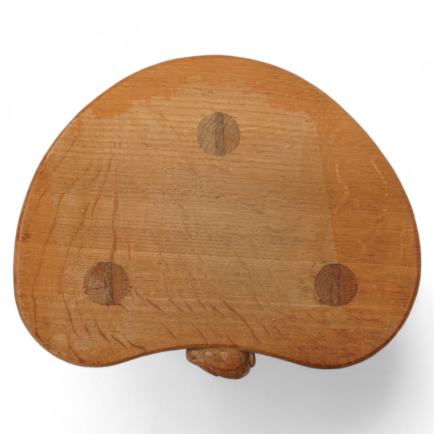 Rabbitman -  oak milking stool, dished kidney shaped top, three tapered octagonal supports, carved with rabbit signature, by Peter Heap, Wetwang