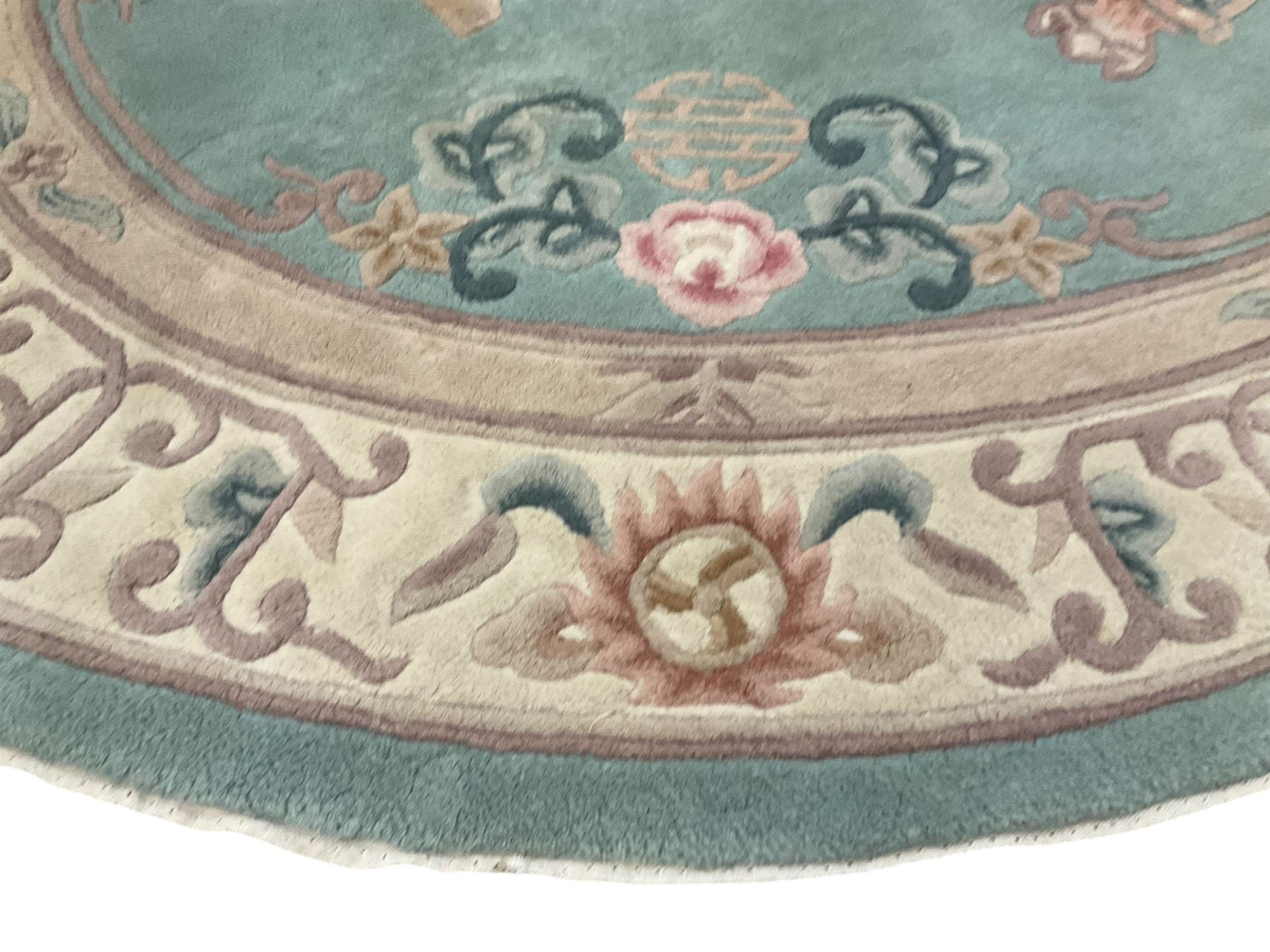 Chinese pale turquoise ground washed woolen rug, oval form decorated with bouquets of floral designs and Chinese characters, enclosed by a wide guard band