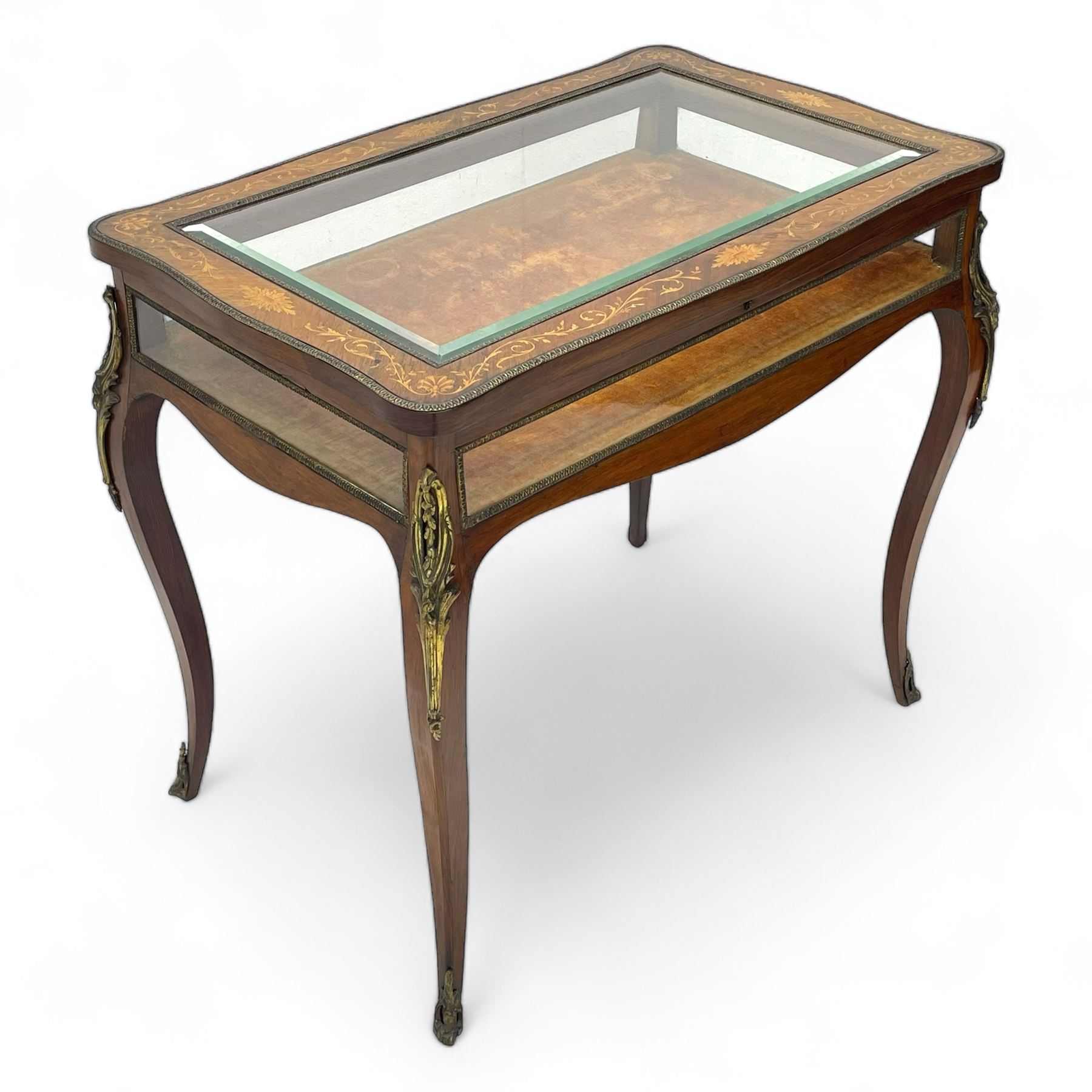 Victorian inlaid rosewood bijouterie table cabinet, shaped form, enclosed by hinged bevel glazed lid with shell and floral inlays, fabric lined interior, glazed sides within foliate cast gilt metal edging, on cabriole supports with floral cast gilt metal mounts and terminal caps 