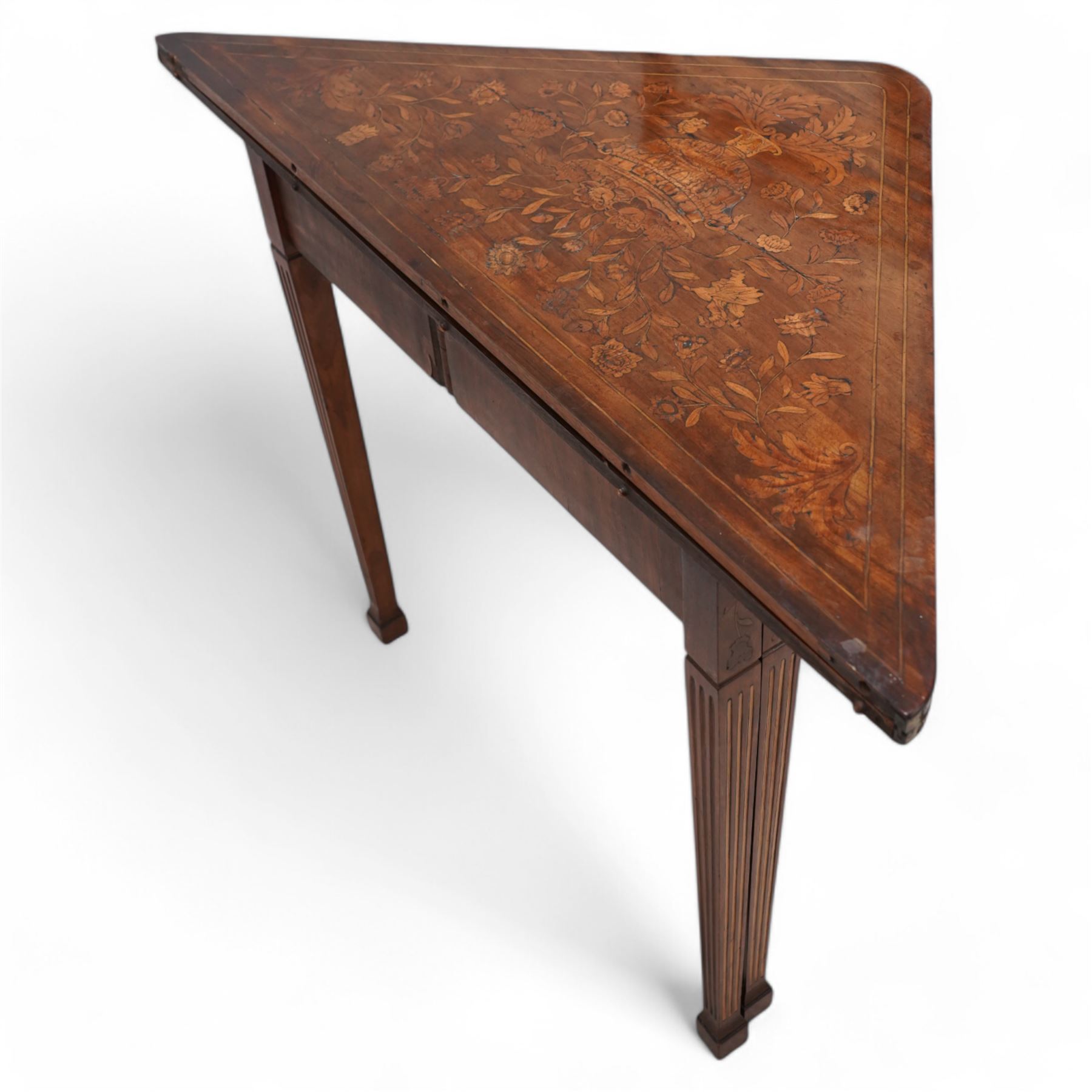 19th century walnut and Dutch marquetry triangular table, the triangular fold-over top reveals a panel of inlaid writing instruments, on square tapering and fluted supports terminating to spade feet 