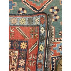 Caucasian turquoise ground rug, two medallions on a field decorated with stylised animal and geometric motifs, the guarded border decorated with further geometric motifs