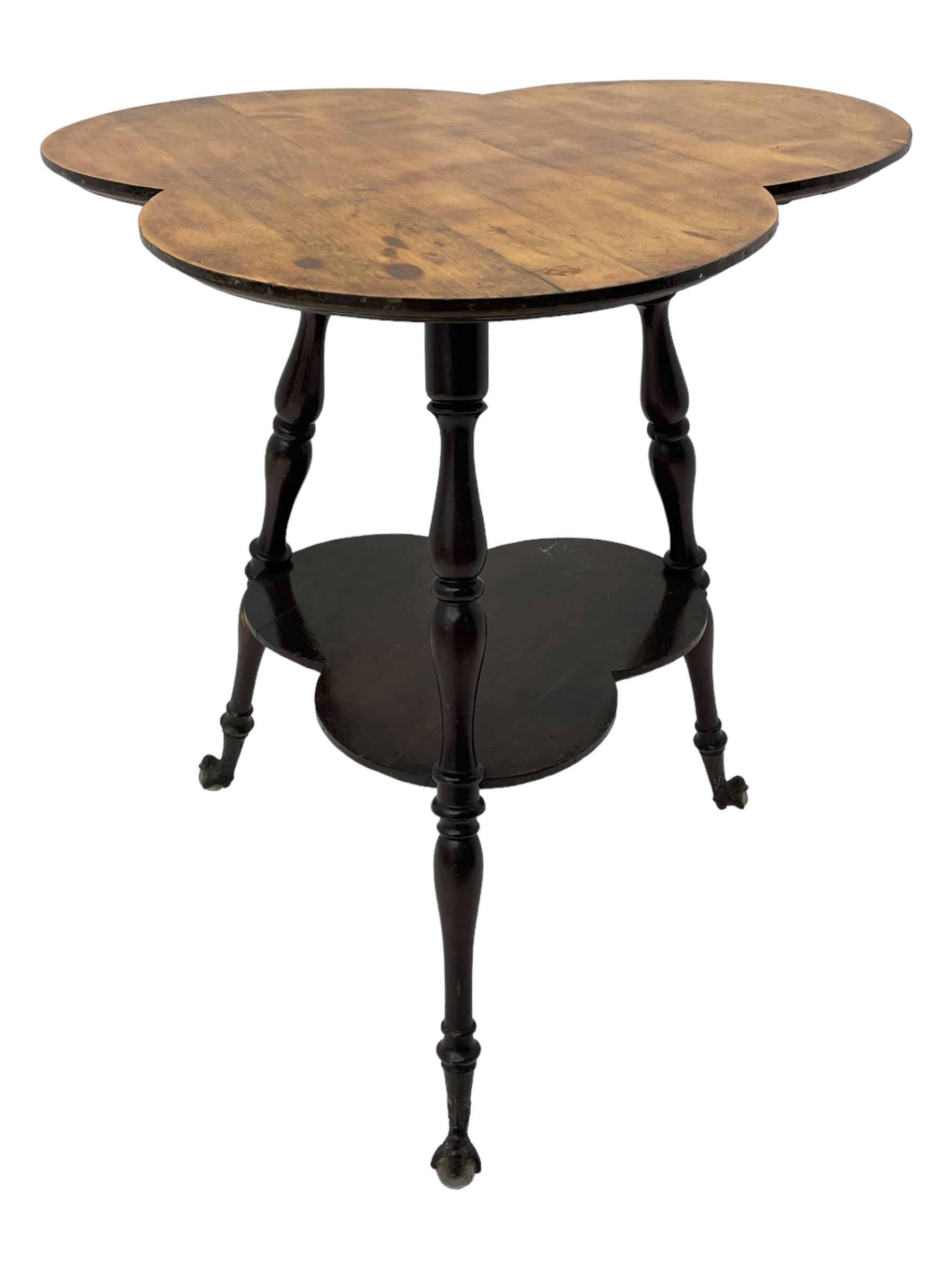 Late 19th to early 20th century stained beech 'Gypsy' table, trefoil or clover shaped top on turned supports united by undertier, on cast metal and glass ball feet 