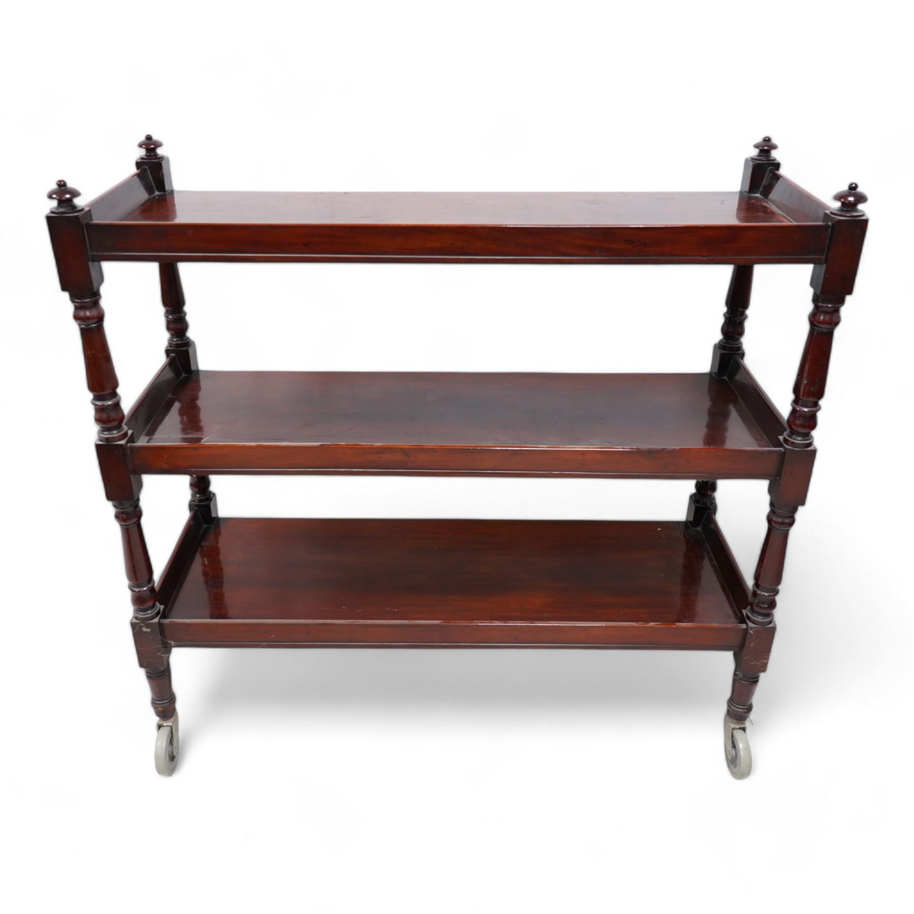 Victorian mahogany three-tier buffet, raised three-quarter gallery back with surmounted turned finials and moulded front edge, raised on turned supports and uprights terminating to castors