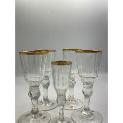 Set of four 19th century Baccarat liqueur/sherry glasses, circa 1820, with panelled bucket bowls and gilt rims, engraved CEG, to faceted knopped stems, together with another smaller example, H14cm and H12cm (5)