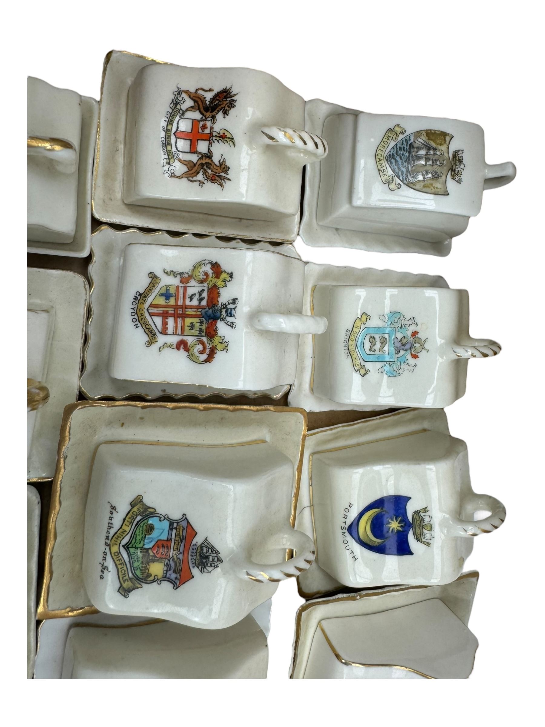 Collection of crested ware miniature cheese dishes and covers, including one by Goss, in one box