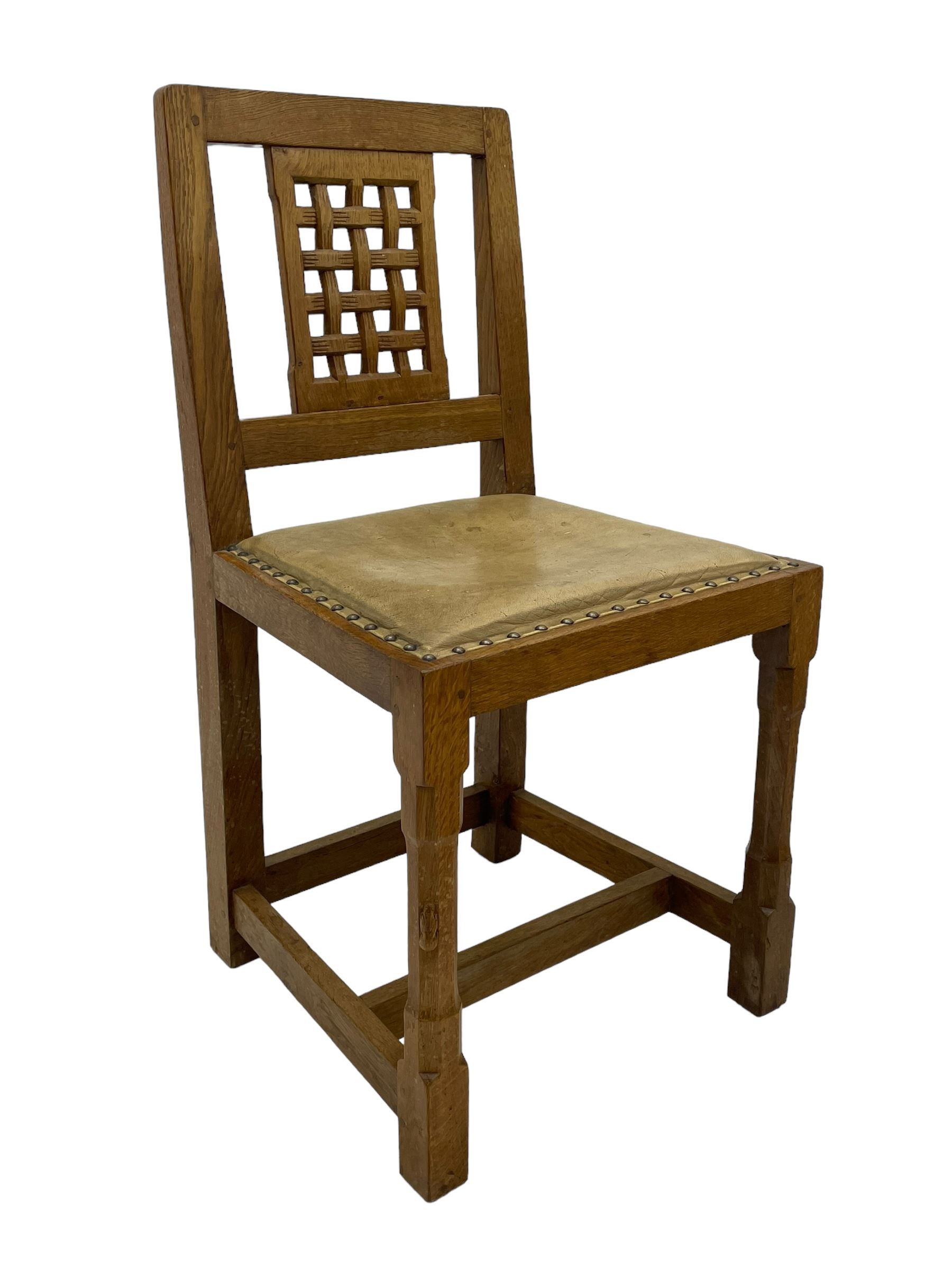 Rabbitman - set of six (5+1) oak dining chairs, pierced and carved lattice back, leather upholstered seat with stud band, on octagonal supports united by stretchers, carved with rabbit signature, by Peter Heap of Wetwang 