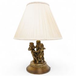 Gilt metal table lamp, of classical design, the stem surrounded by three putti figures hol...