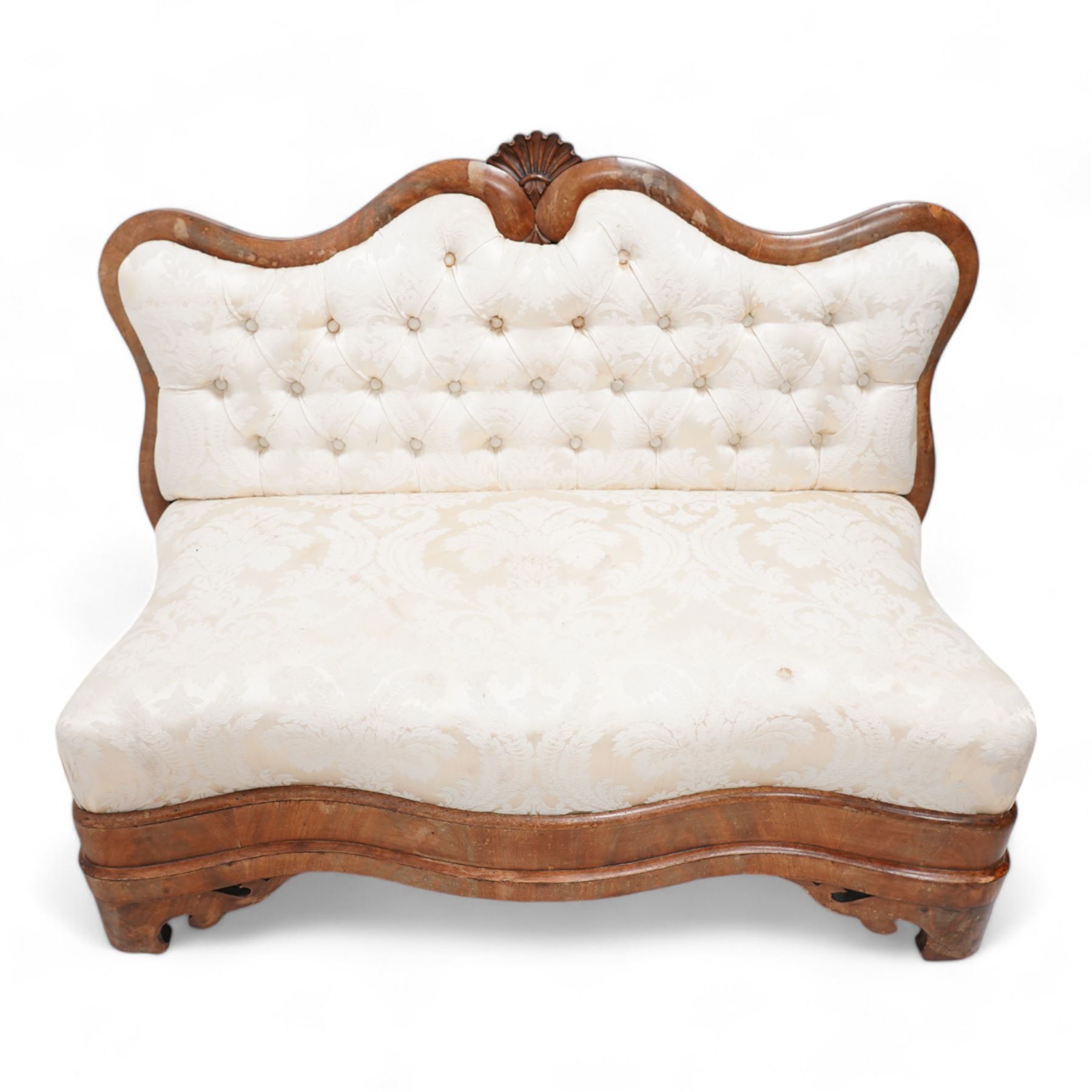 Victorian mahogany frame settee, shaped cresting rail with fan carved cresting, upholstered in buttoned cream fabric with repeating floral pattern, low serpentine seat, shaped and pierced bracket feet, on brass castors 