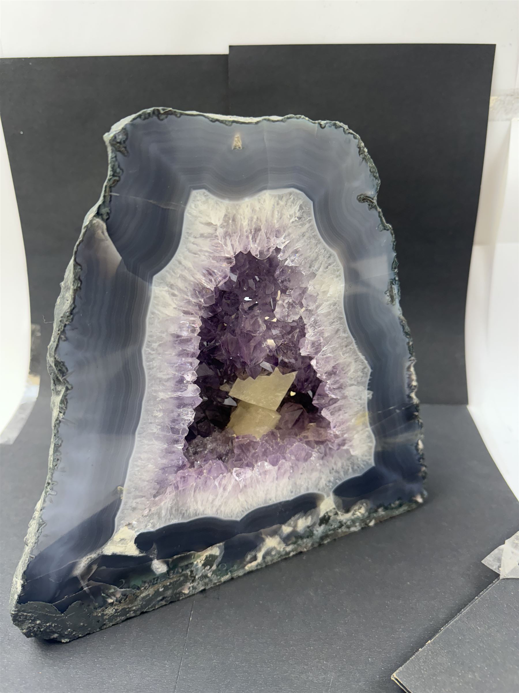 Amethyst crystal ‘cathedral’ geode, free standing with flat base and prepared outer surface, with well-defined crystals of various sizes within the cavern, H25cm, W25cm