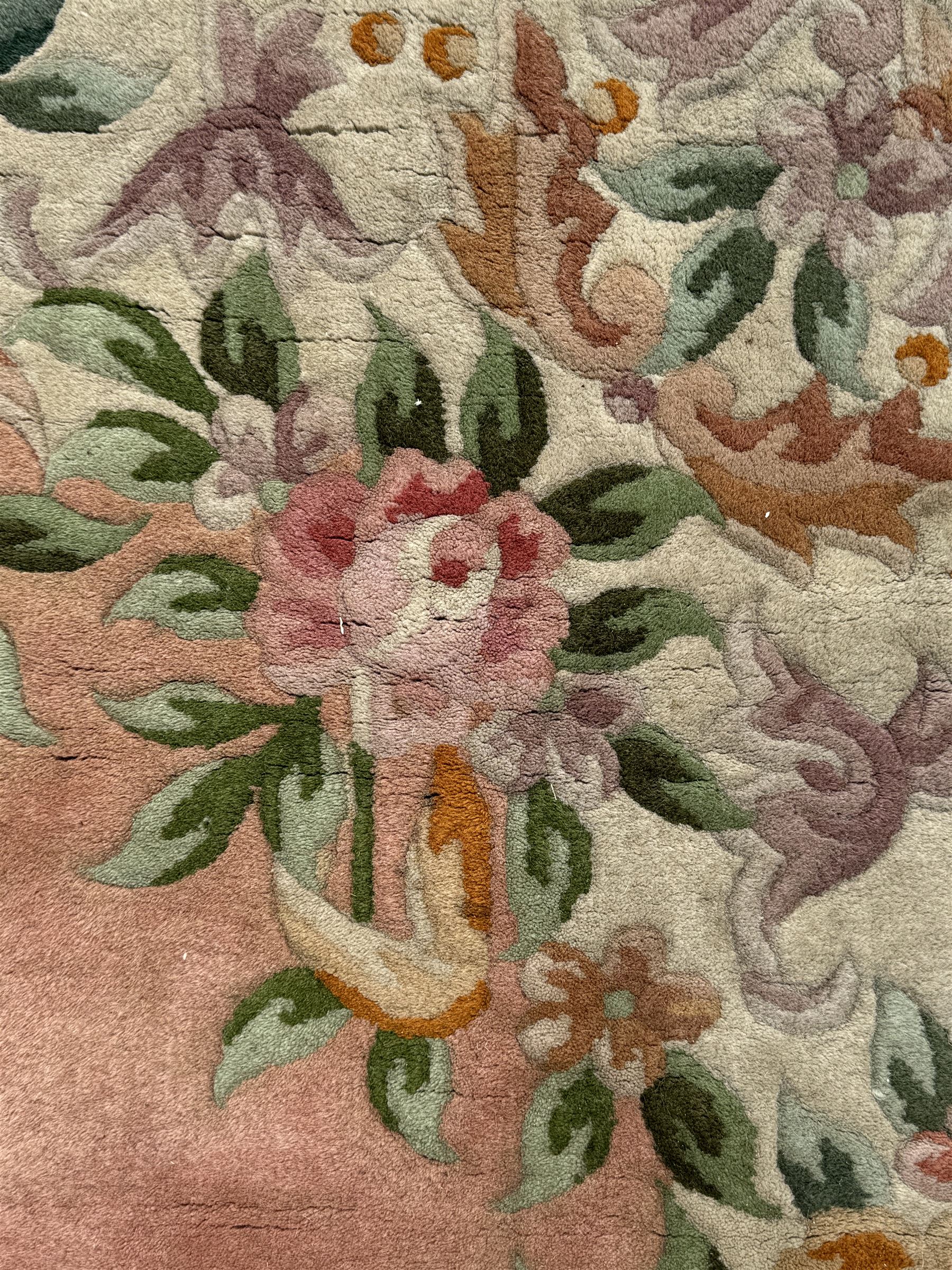 Chinese Aubusson design pink ground rug, the field decorated with an oval medallion filled with floral motifs in pastel shade, surrounded by floral garlands and foliate scrolls