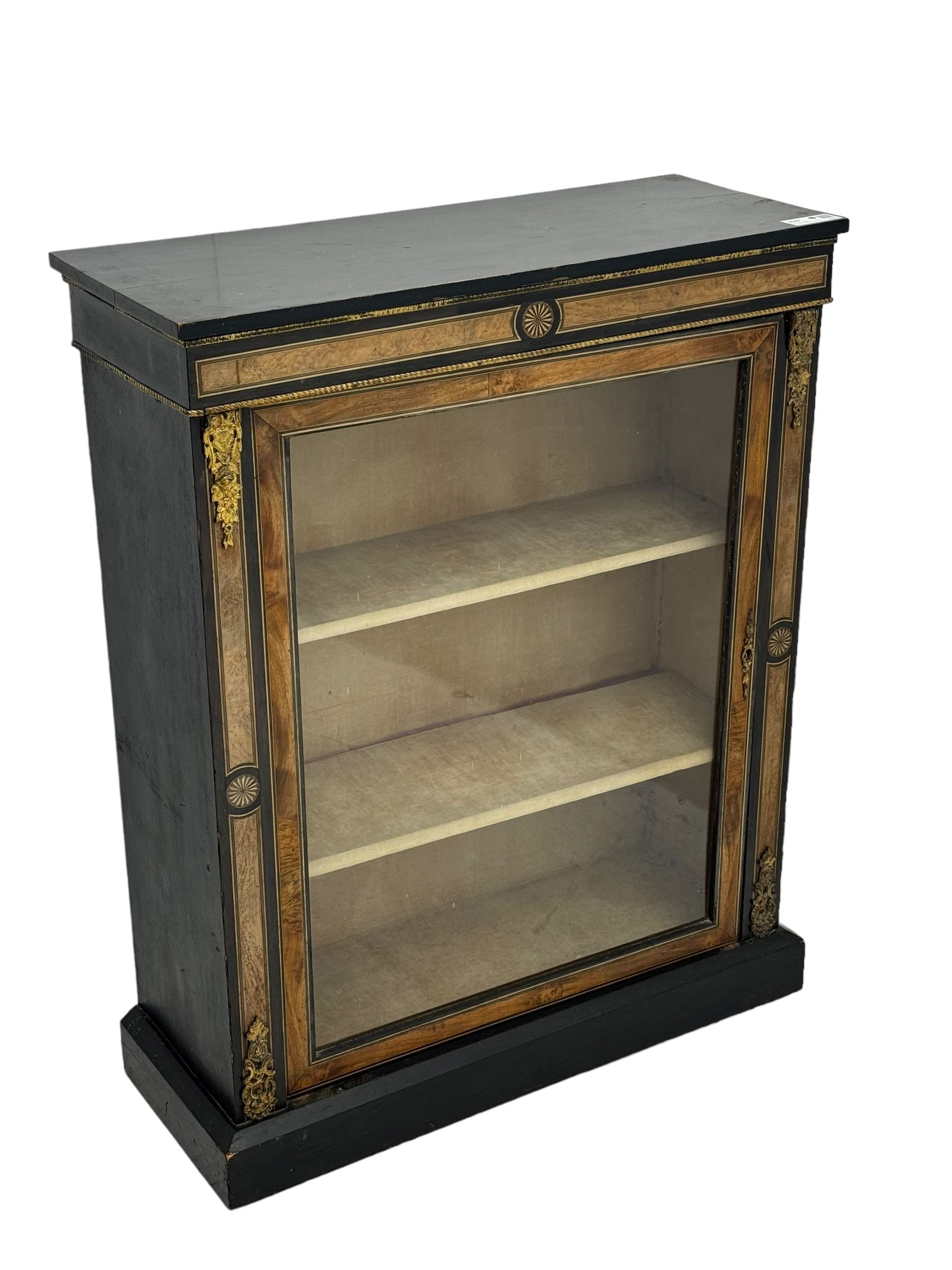 Victorian ebonised and walnut pier cabinet, rectangular top over figured frieze with central star motifs, enclosed by single glazed door, decorated with cast gilt metal mounts and beading, on chamfered plinth base 