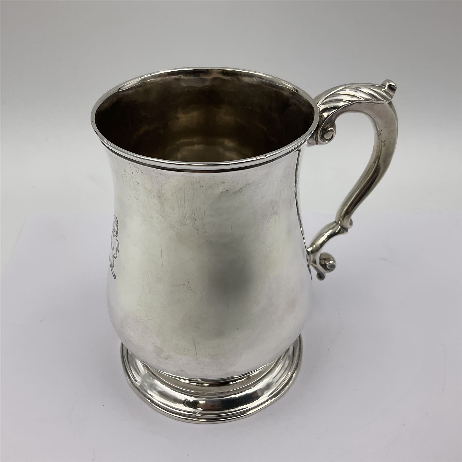 George II silver tankard, of waisted baluster form with acanthus capped C scroll handle, the body engraved with a lion rampant, upon a circular spreading foot, hallmarked Gabriel Sleath & Francis Crump, London 1754, H13cm