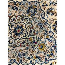 Persian Kashan golden ivory ground carpet, the central medallion surrounded by a field of interlacing branch and stylised plant motifs, the guarded border with scrolling design decorated with flower heads 