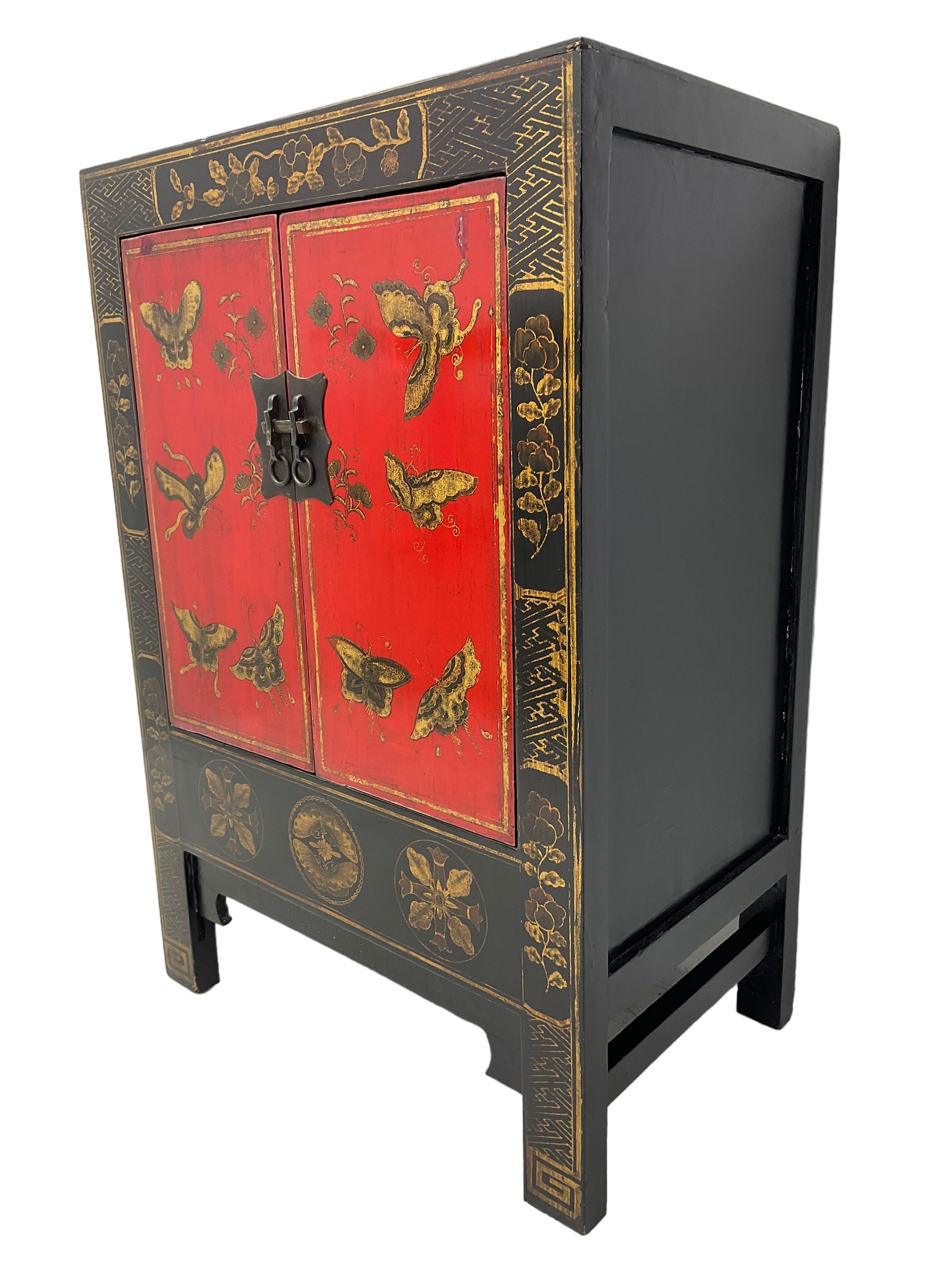 20th century Chinese black lacquered cabinet, rectangular body with two doors enclosing single shelf interior, adorned with gilt butterfly and floral motifs against a red backdrop, standing on square supports