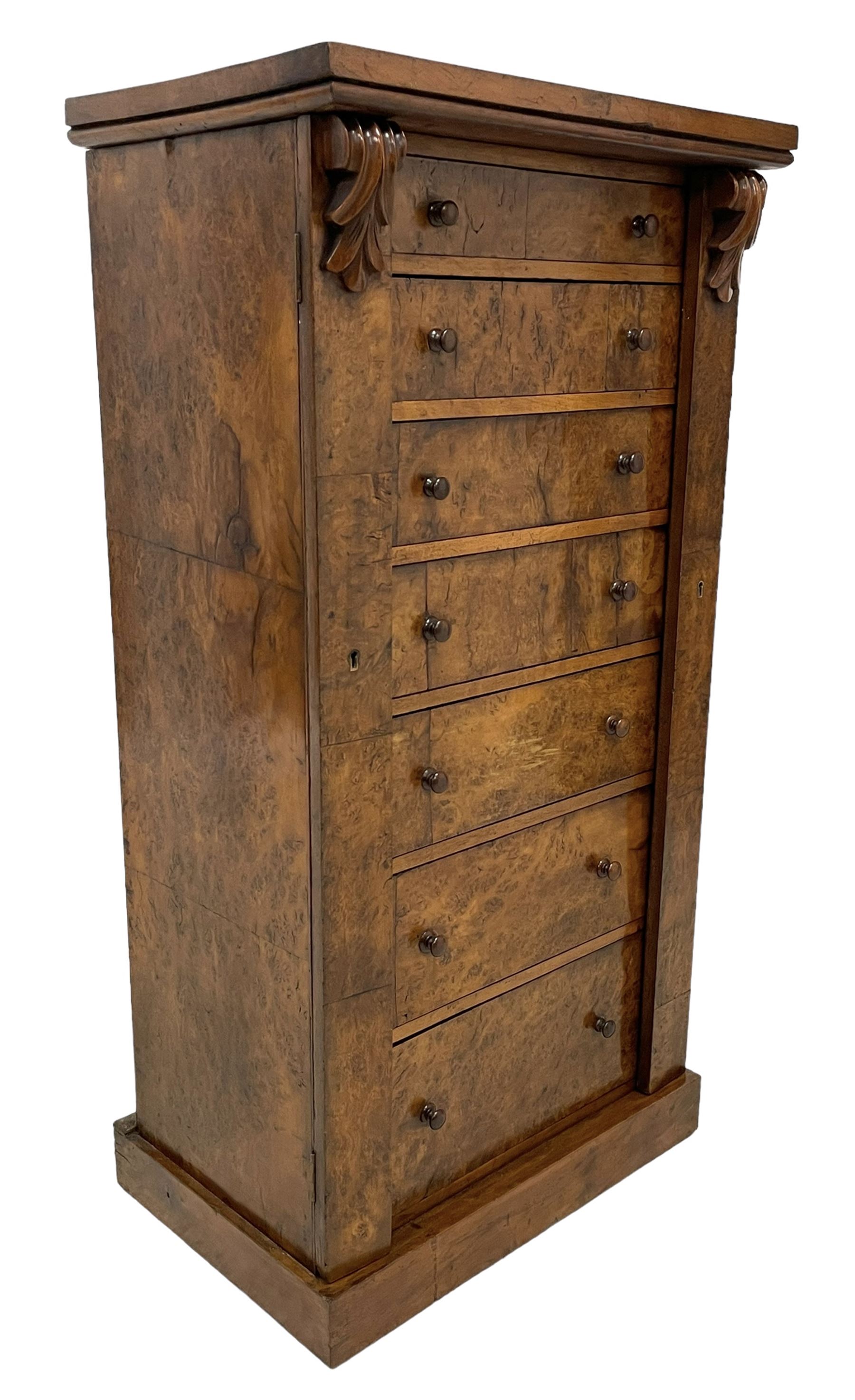 Victorian burr walnut Wellington chest, rectangular top with book-matched veneers, two hinged uprights with scrolled foliage carved brackets enclosing seven graduating drawers, on plinth base 