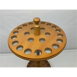 Pine stick stand, with turned central column dividing two circular tiers, upon three feet, with capacity for twenty four walking sticks, H73cm