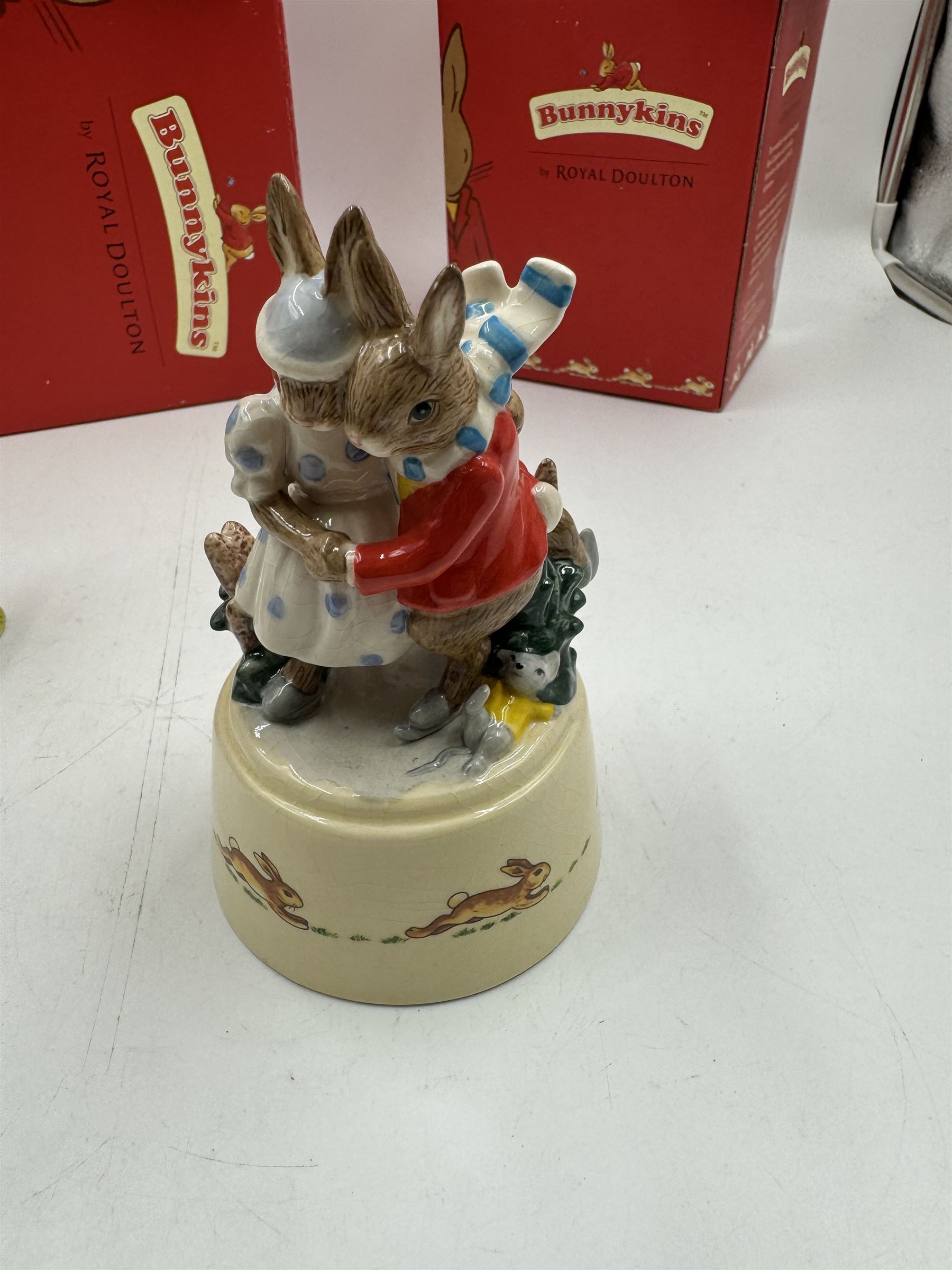 Two Royal Doulton Bunnykins music boxes, comprising Rocking Horse and Winter Waltz together with two Royal Doulton Bunnykins figures Once Upon a Time and Father, Mother & Victoria, all with original boxes  