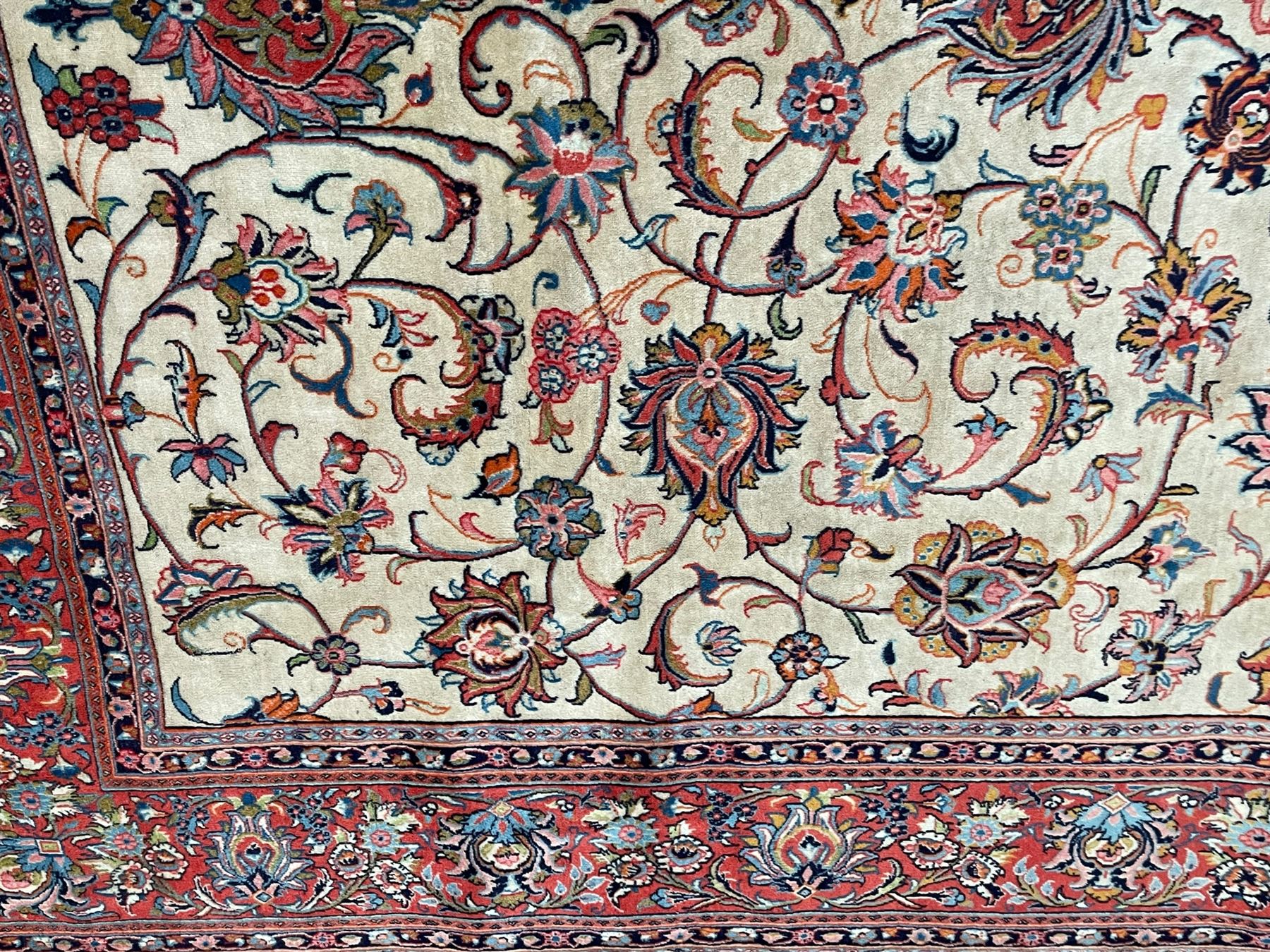 Persian Sarough ivory ground rug, the field decorated with curled leafy branches and palmettes, crimson ground border decorated with further palmettes and floral sprays, within guard stripes 