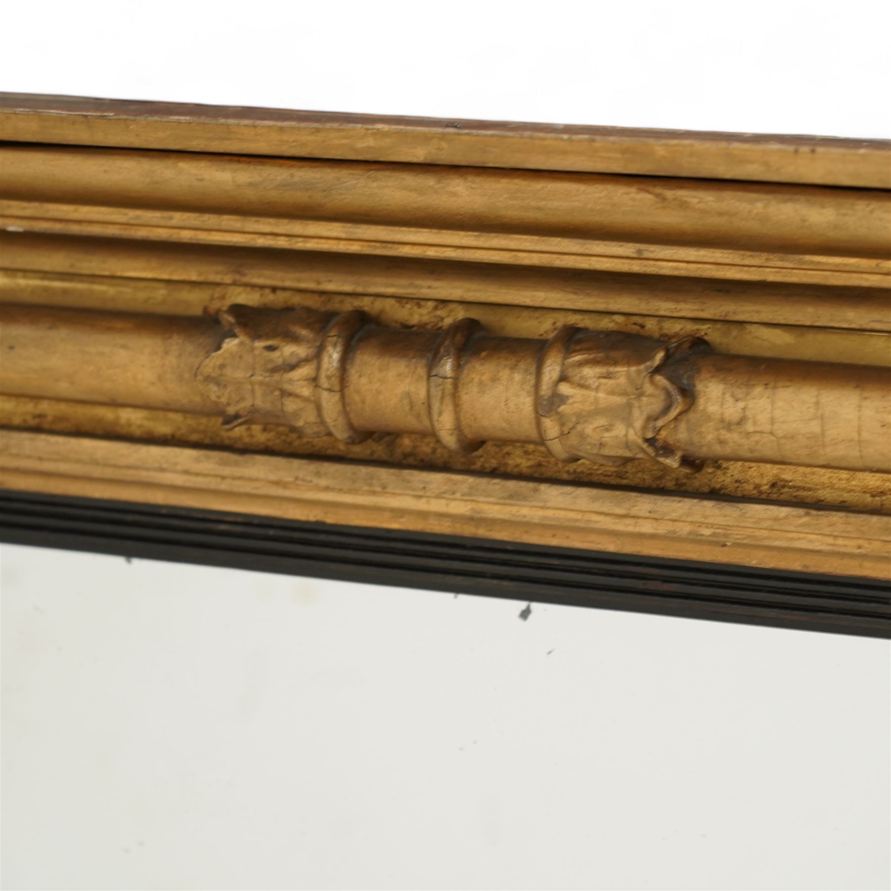 Regency gilt wood overmantel mirror, moulded cornice with projecting square ends, fitted with three turned column mounts with foliage decoration, ebonised and reed moulded slip dividing the mirror into three sections, moulded lower rail, plain mirror plates