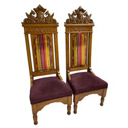 Set of six 20th century Carolean design oak high back chairs, the pediment carved with dragons and central Green Man mask with trailing foliage, the backs upholstered in striped fabric, on turned front supports