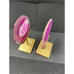 Pair of pink agate slices, polished with rough edges, raised upon gilt metal stands, H20cm