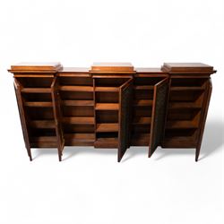 Large 19th century figured mahogany bookcase, enclosed by five brass grille panel doors, the interior fitted with adjustable shelves, double drop centre and break front with raised stepped tops, on plinth base 