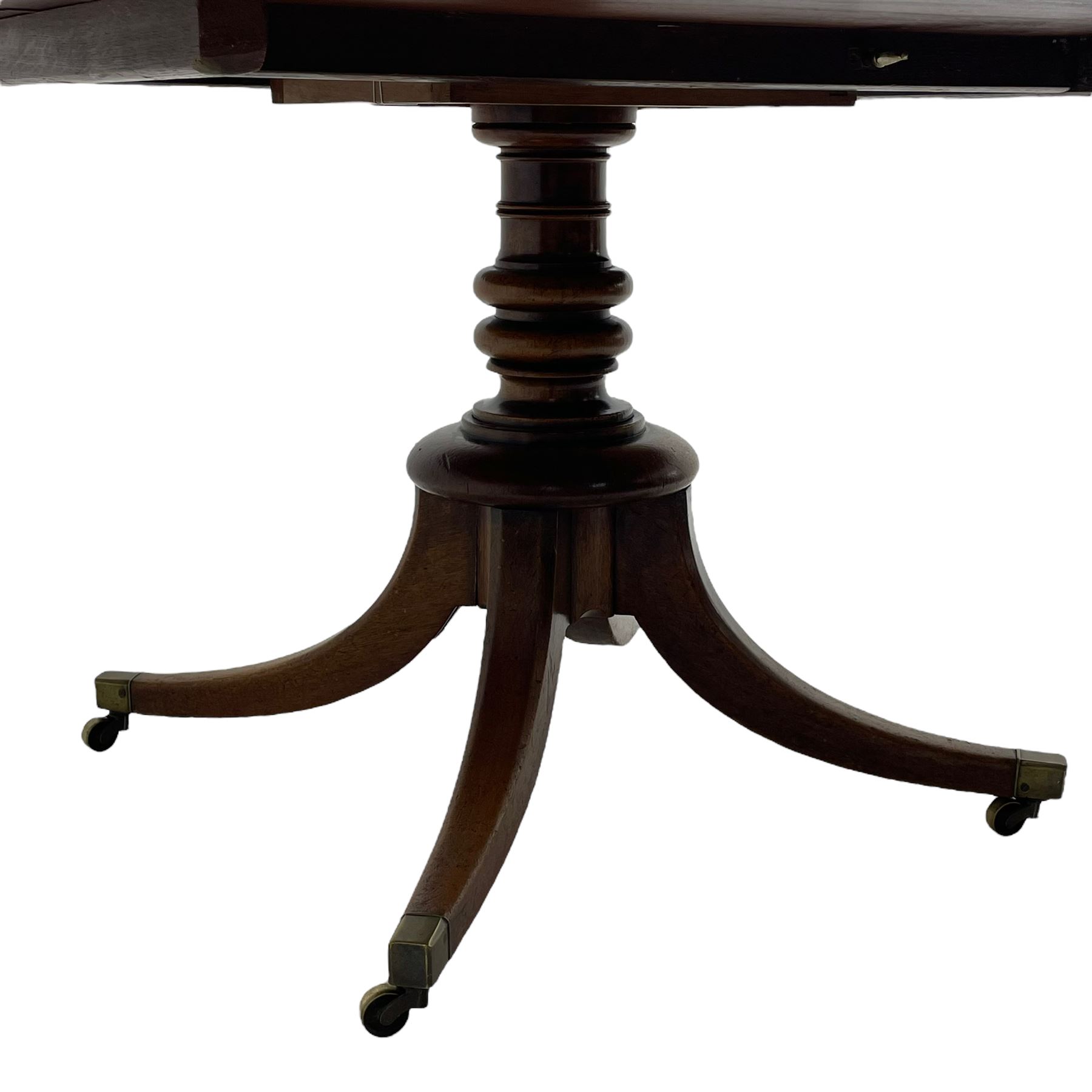 George III mahogany breakfast table, oval tilt-top on turned column with four splayed supports, fitted with brass cups and castors 