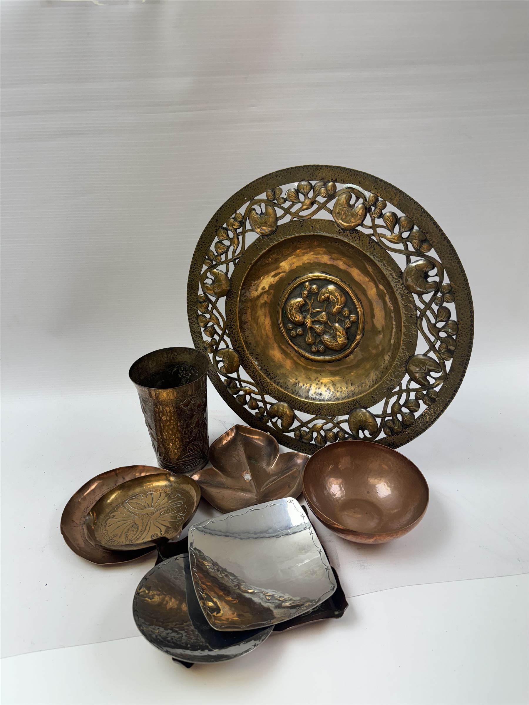 Keswick School of Industrial Arts, flared vase of cylindrical form, together with an Arts and Crafts plated copper, an embossed tray, copper dishes and charger 