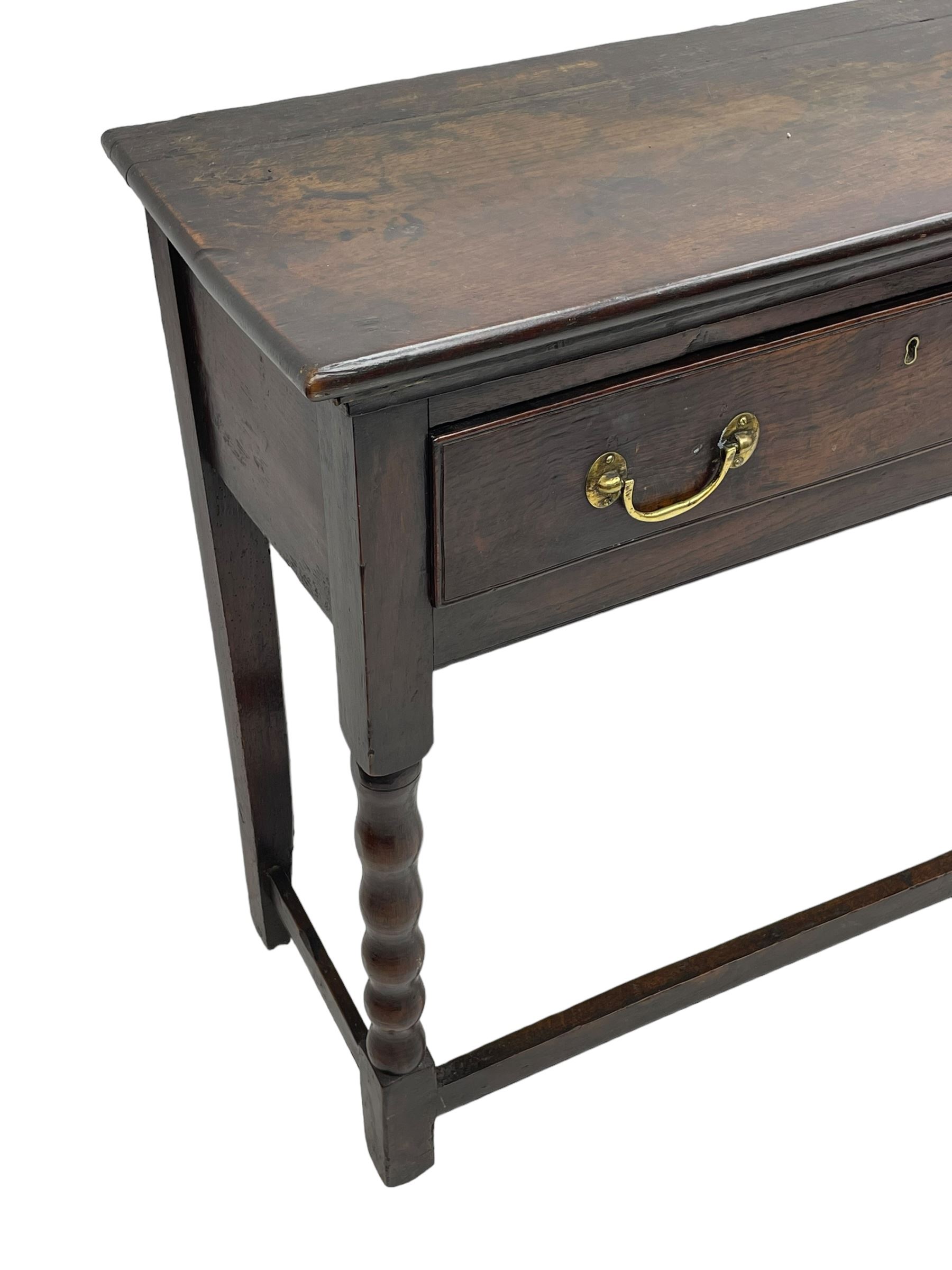 18th century oak dresser base, rectangular top, fitted with two drawers with moulded facia edges and brass swan neck handles, raised on turned front supports united by stretchers