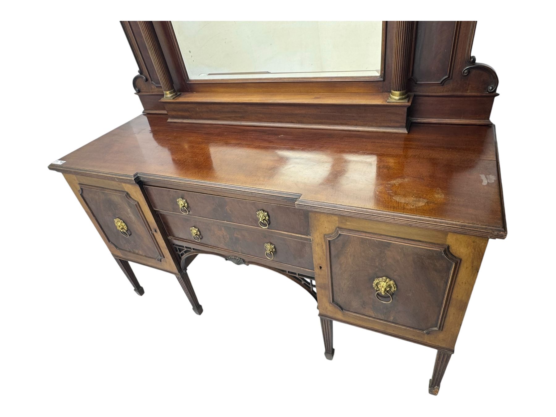 19th century mahogany sideboard, raised mirror back with carved fretwork and two fluted columns, above two cupboards and two drawers with lion mask handles