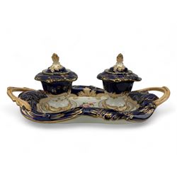 19th century porcelain inkstand, the oblong twin handled base centrally painted with a floral bouquet, flanked by two footed inkwells and covers, with rococo-inspired acanthus moulded borders and handles, pattern no. 2/3339, L26.5cm 