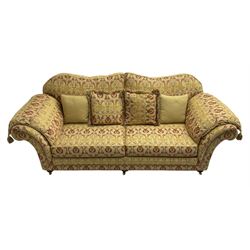 Steed Upholstery Ltd. - 'Lincoln' three-seat sofa upholstered in gold 'Olympia' floral pattern corded and tasselled fabric, together with scatter cushions and arm covers, on turned feet with brass castors