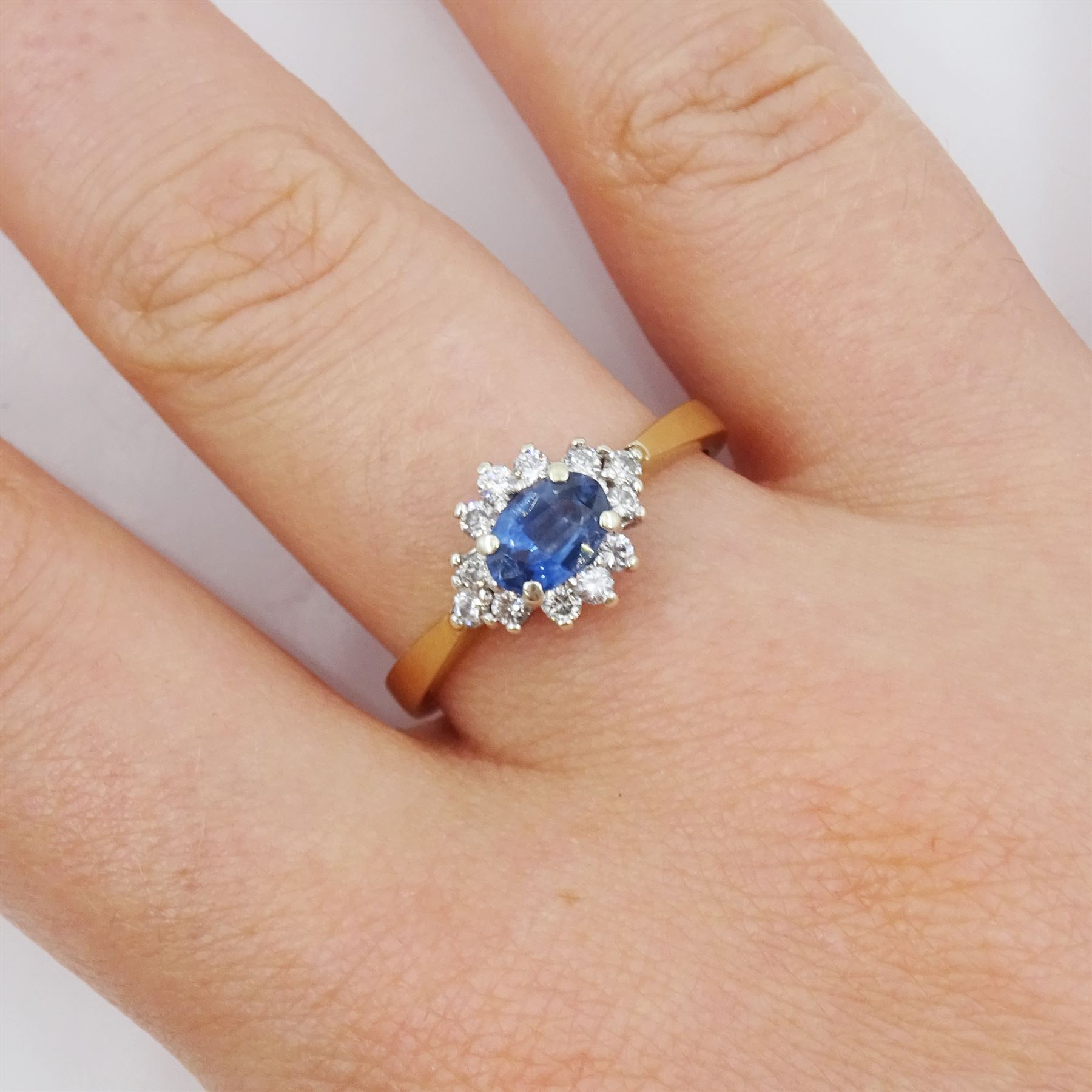 9ct gold oval sapphire and round brilliant cut diamond cluster ring, hallmarked London 1994, sapphire approx 0.55 carat, total diamond weight approx 0.25 carat