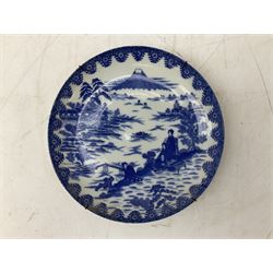 18th century Delft blue and white charger, densely decorated with painted stylised floral motifs and foliage, with painted symbols to reverse, A/F, D35cm, together with an Oriental style blue and white dish with figures in a mountainous landscape, D24cm (2)