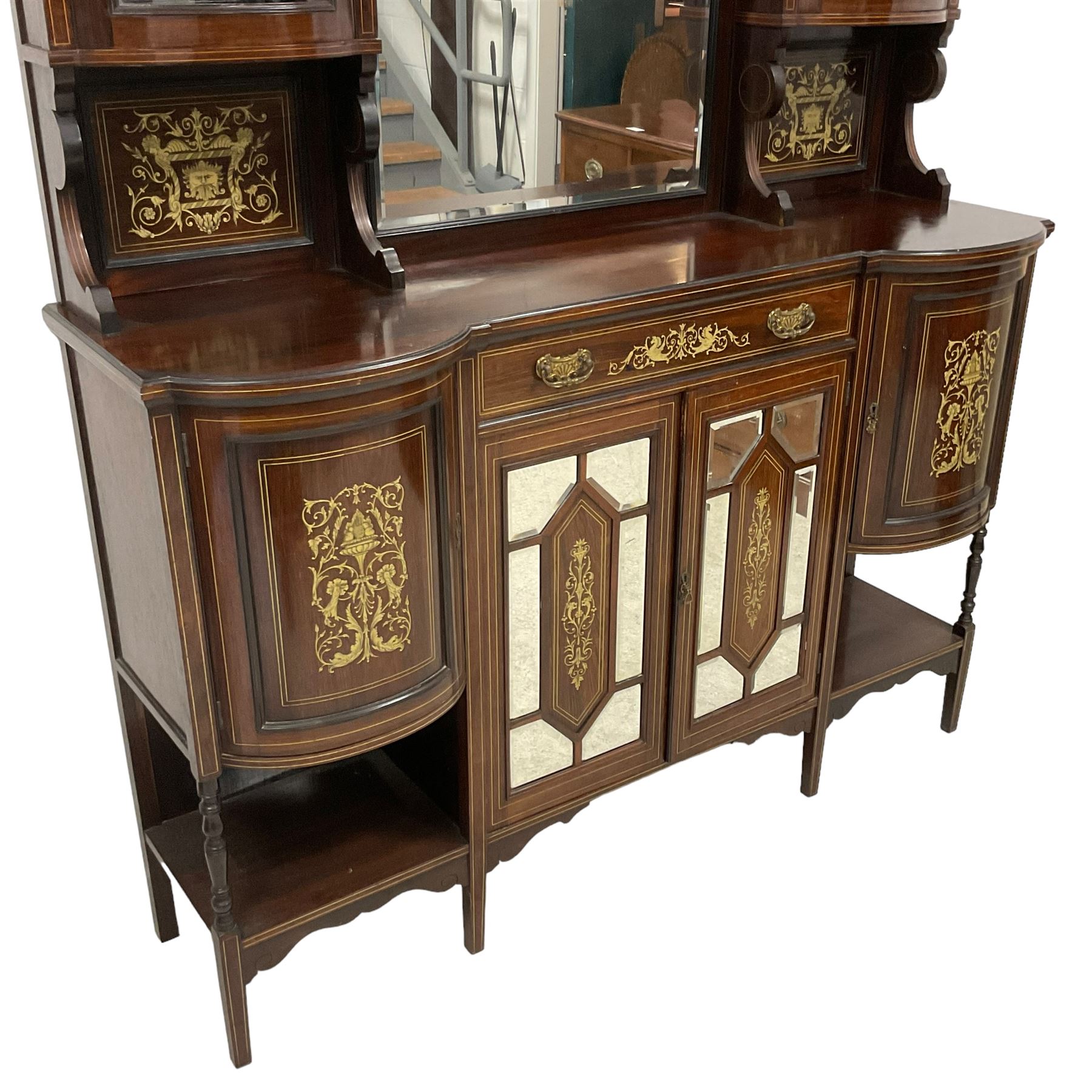 Late Victorian inlaid rosewood mirror back sideboard, shaped cresting rail decorated with scrolling foliate ivorine inlays, over rectangular bevelled mirror, flanked by bow-front glazed cupboards over inlaid 'green man' motifs, the base fitted with single drawer and cylindrical cupboards flanking a mirror panelled cupboard, on square tapering supports