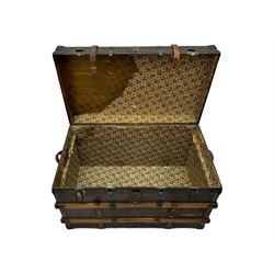 Early 20th century 'McBrine Baggage' steamer trunk, oak frame and black canvas covering, featuring metal hardware and leather straps, fitted with central lock, additional latches, and corner protectors, the interior is lined with floral-patterned paper and includes a removable top tray with makers label 