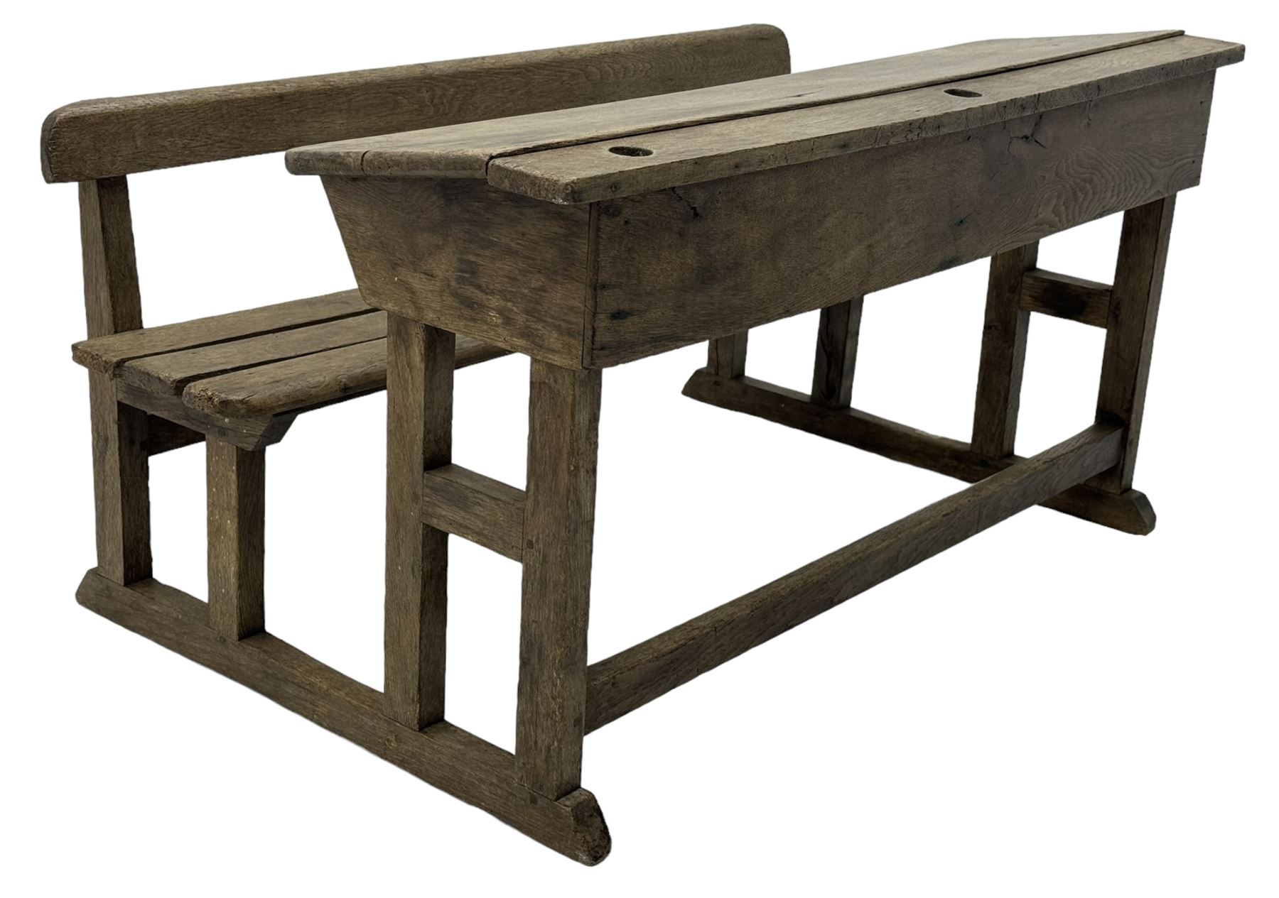 Victorian child's pine double school desk, the writing surface with two inkwells and two shelves underneath, integrated slatted bench seat raised on supports united by stretcher 