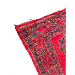 Early 20th century Western Anatolia Turkish Oushak crimson ground carpet, the field decorated with rows of Herati and Palmette medallions, the main border decorated with stylised flower head motifs within guard stripes