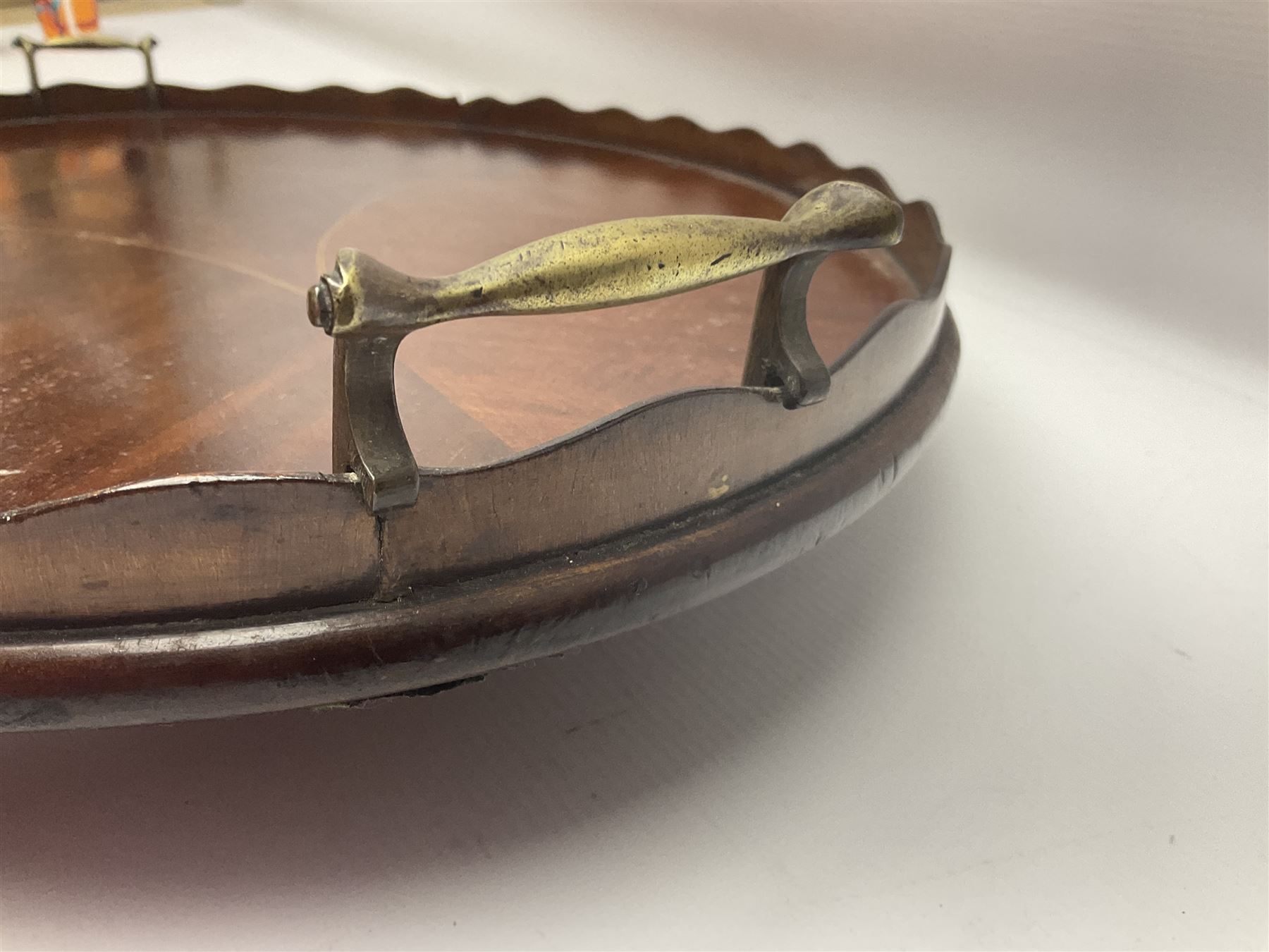 Early 20th century mahogany tray, of oval form with shaped rim and twin brass handles, with inlaid diamond decoration to centre, W67cm