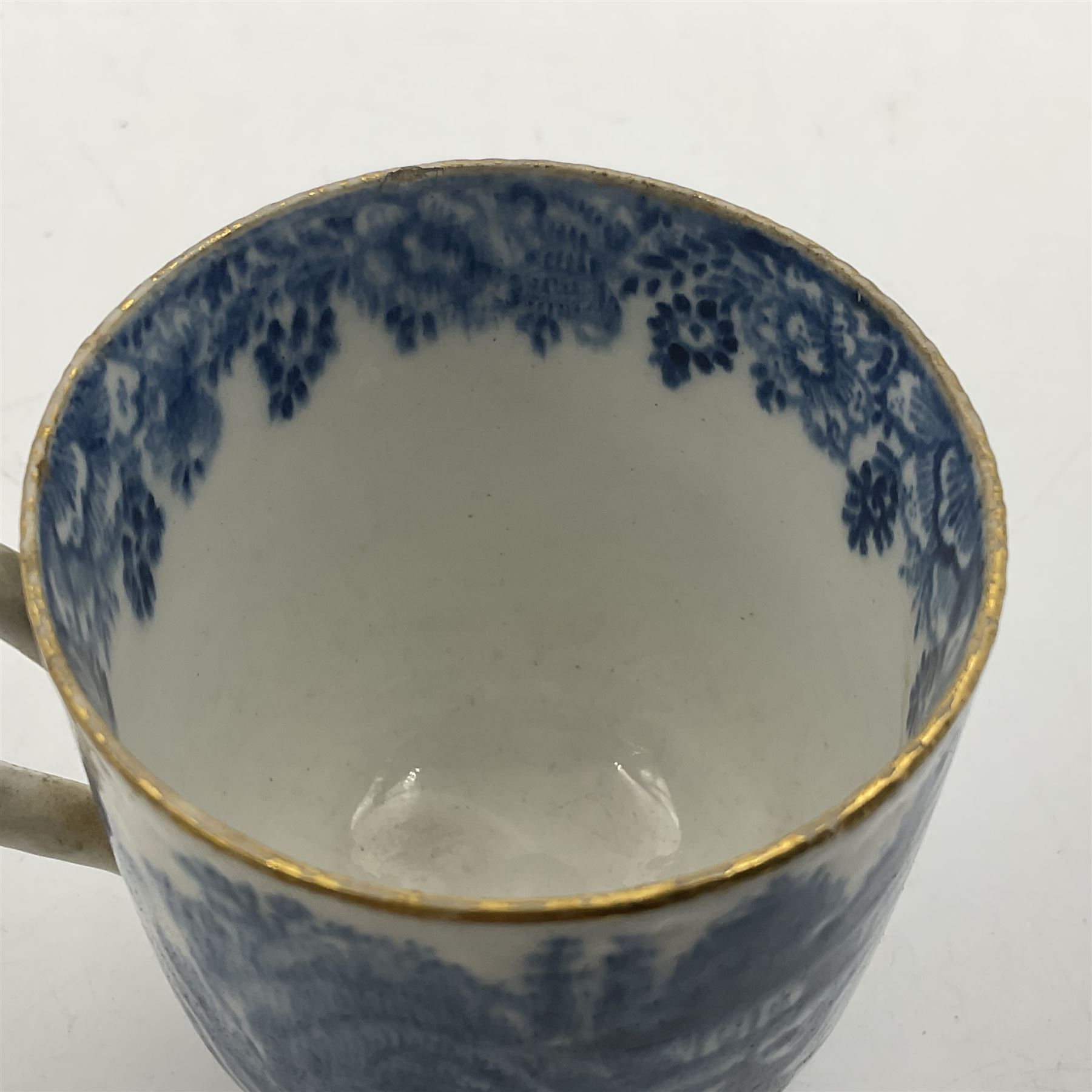 Rare 18th century Bow porcelain coffee cup, circa 1765-1770, profusely decorated with figures and dwellings in a rocky landscape, the interior with wide foliate border, H6cm