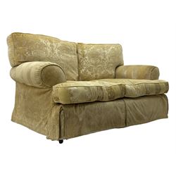 Contemporary two-seat sofa, upholstered in damask fabric with a pale gold floral pattern, rolled arms, loose back and seat cushions, on matching skirted base with concealed castors