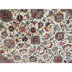 Persian Sarough ivory ground rug, the field decorated with curled leafy branches and palmettes, crimson ground border decorated with further palmettes and floral sprays, within guard stripes 