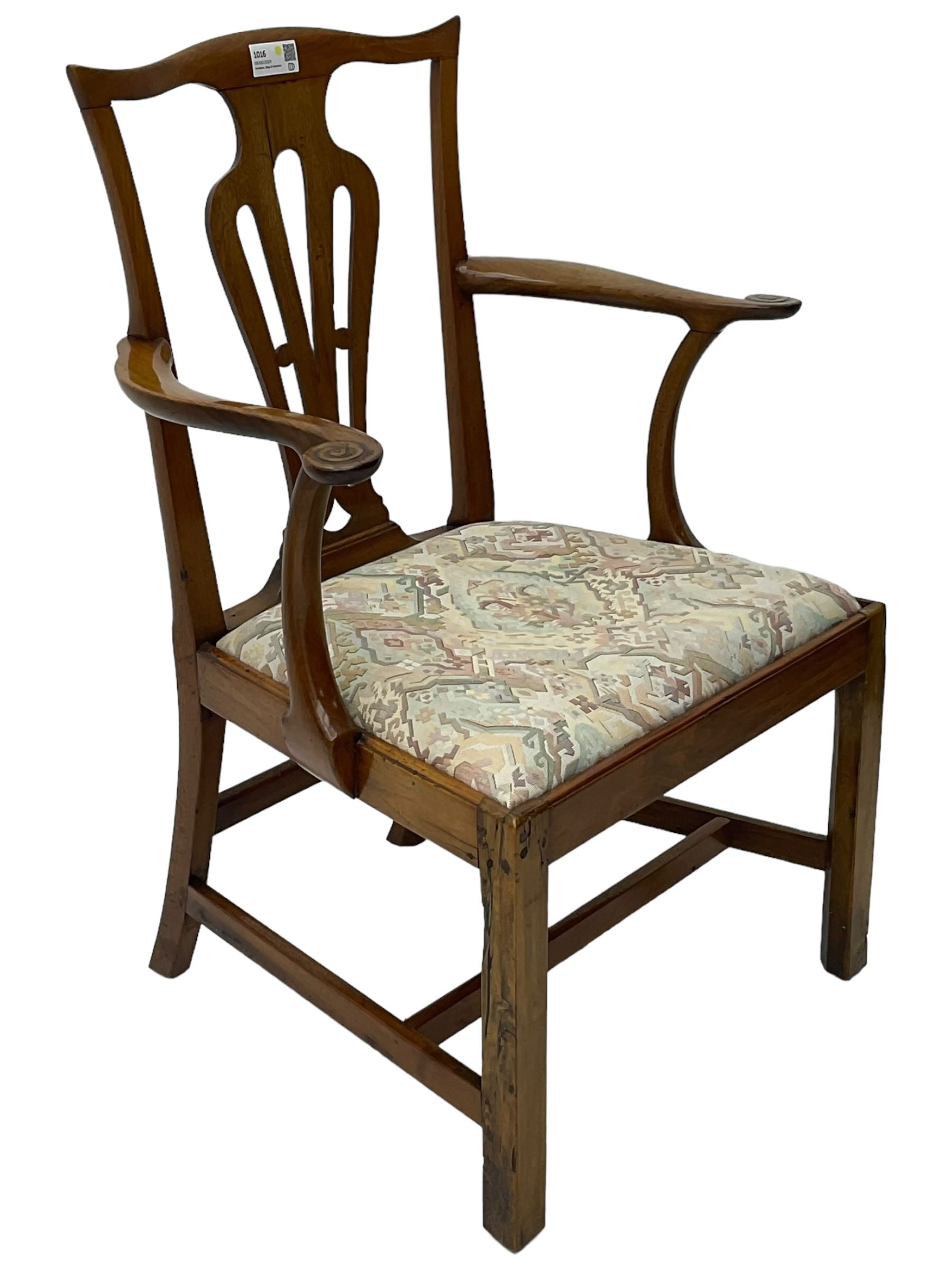 George III walnut elbow chair, shaped cresting rail over shaped pierced splat, the shaped arms with scroll carved terminals, upholstered drop in seat, on square chamfered supports united by plain stretchers 