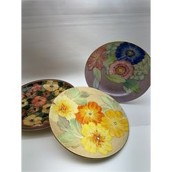 Two Gray's pottery charges, decorated with flowers, together with another charger by Jersey pottery