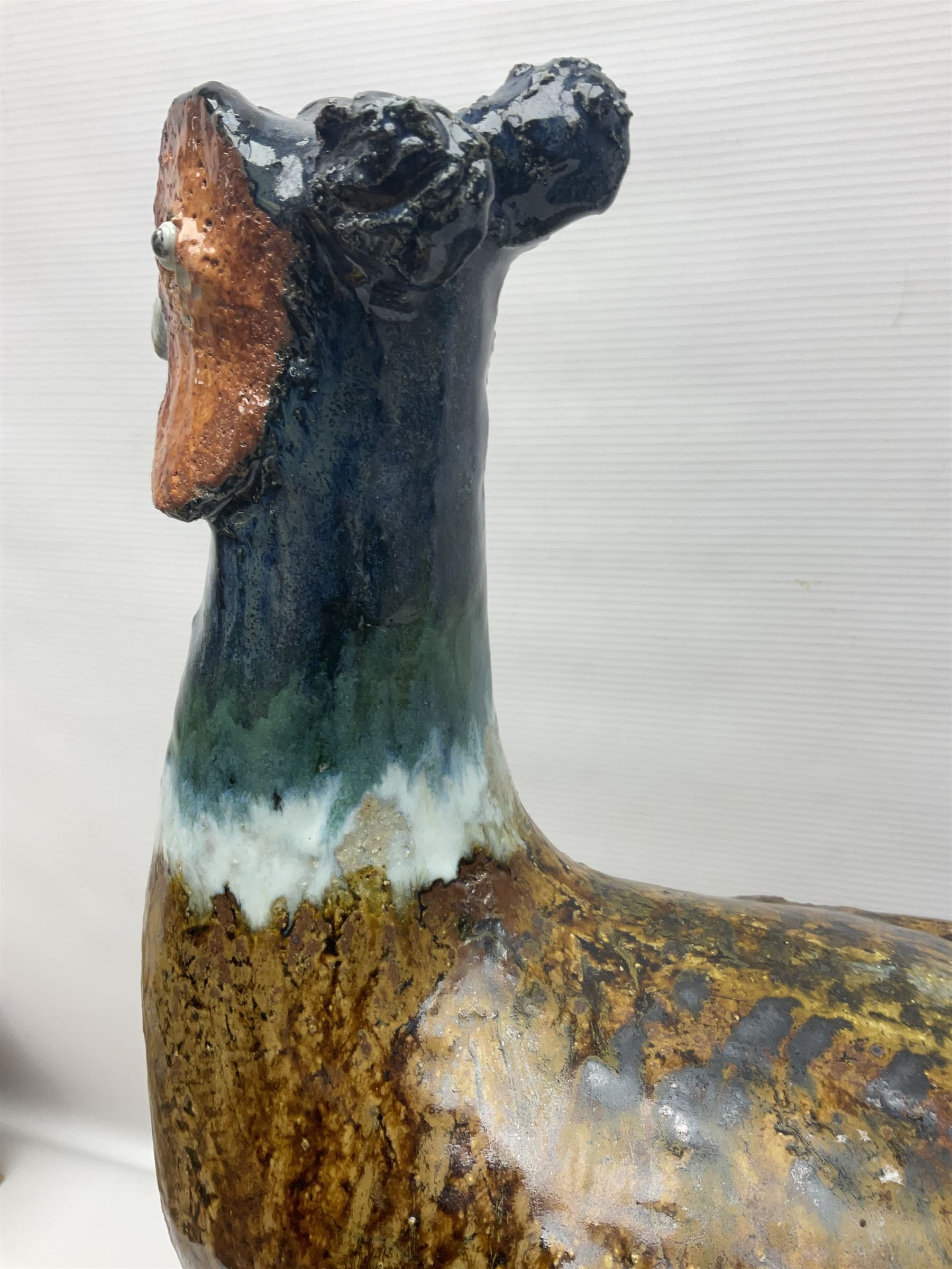 Large stoneware sculpture modeled as a Ring Neck Pheasant, upon a naturalistic base, H55cm, L78cm