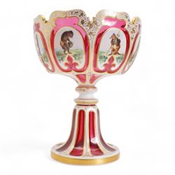 Late 19th century Bohemian white overlaid cranberry glass pedestal bowl, with fancy scalloped rim and cut with oval and fleur de lis shaped panels, each enamelled with 'Reynard the Fox' anthropomorphic animals, after the illustrations by Wiilhem Von Kaulbach,  within gold borders with gilt scrolling decoration, supported by a slice cut circular spreading foot with further gilt decoration, H28.5cm x W22.5cm